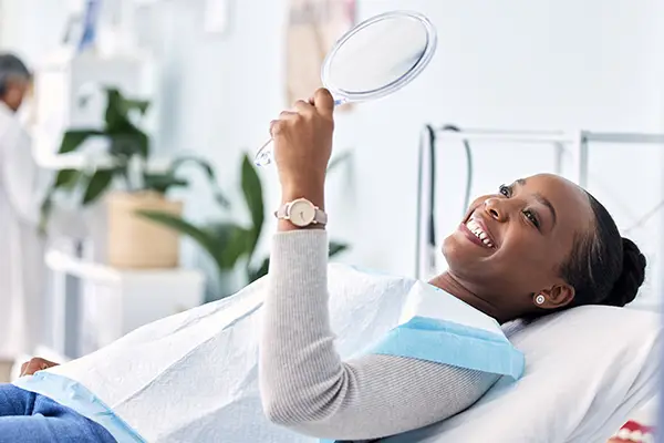 Smile  mirror and black woman at dentist on chair in clinic  tooth treatment and cleaning  tooth treatment and cleaning. Reflection  dental  orthodontics  happy person  teeth whitening  oral hygiene and healthcare for wellness